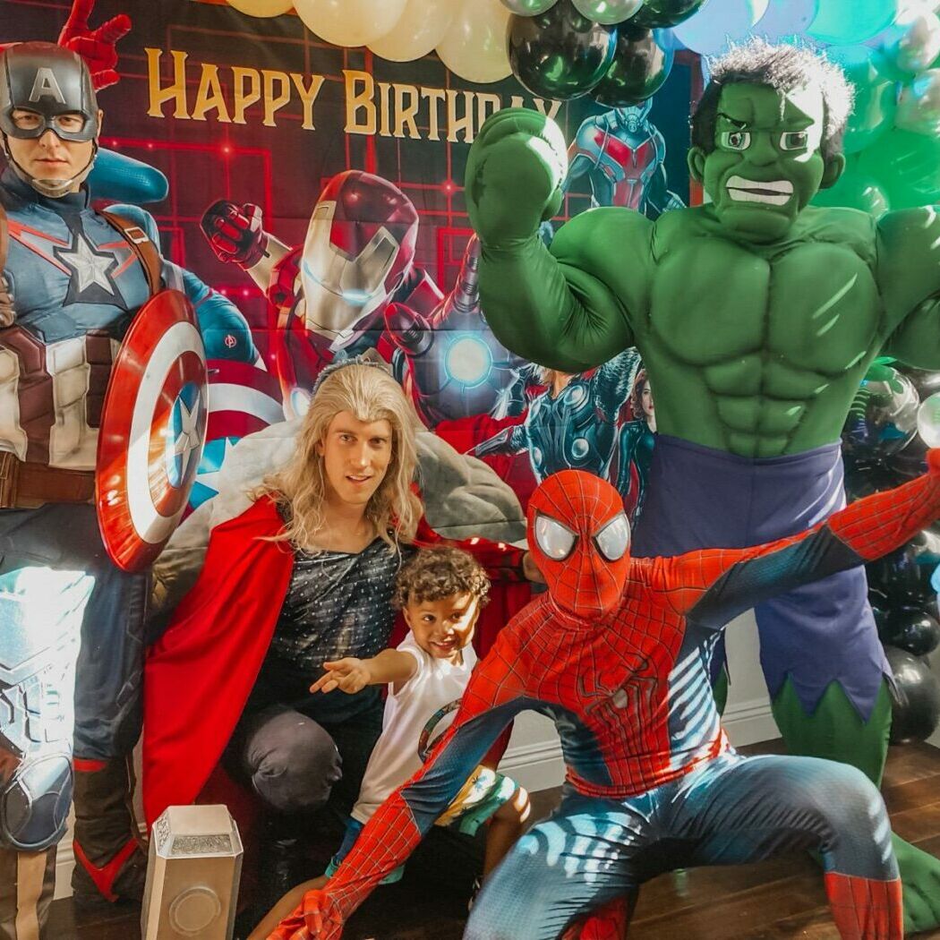 Outdoor birthday party featuring Spiderman entertaining children in a backyard setting.