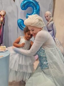 A princess character reading a story to a group of kids at a party.