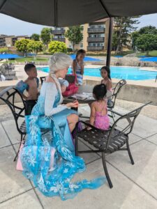 Elsa-themed birthday decorations with blue balloons, snowflake garlands, and frosty table settings.