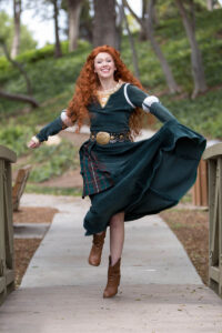 A Merida performer leading an archery-themed activity at a birthday party.