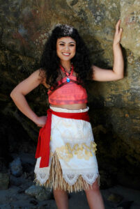 A Hawaiian Princess performer teaching children a hula dance at a birthday party.