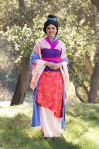 A Mulan performer demonstrating a sword-fighting activity with children.