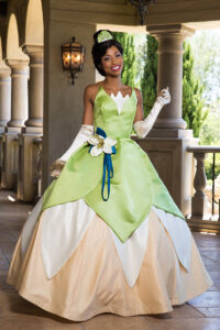 Princess Tiana performer dancing with children at a themed birthday celebration.