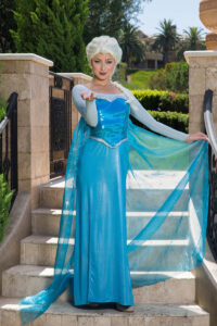 A snow Queen standing in front of a stairway facing the camera.